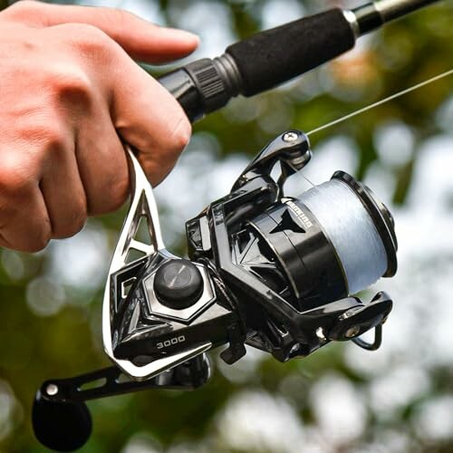 Close-up of a hand holding a fishing reel.