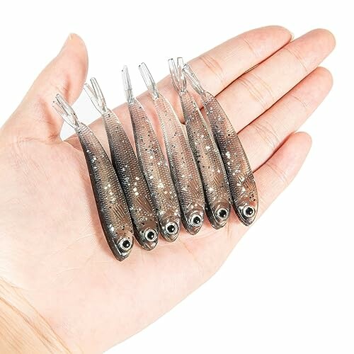 Hand holding six small fish lures
