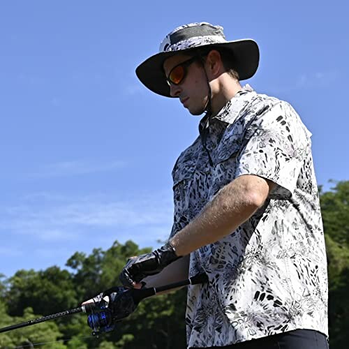 Man fishing outdoors wearing a hat and sunglasses